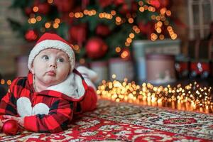 liten sex månad gammal bebis klädd som santa claus. bakgrund för jul kort. de barn utseende upp på de plats för inskrift. foto