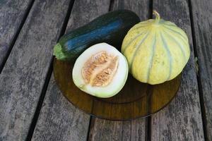 gmo -fria meloner och zucchini på ett träbord foto