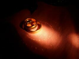 par av bröllop ringa med unik ljus reflektioner foto