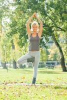 skön kvinna utövar yoga utomhus- foto