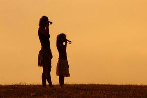 mor och dotter är dricka vatten på solnedgång foto