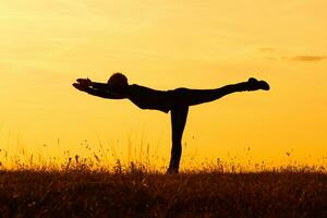 silhuett av kvinna håller på med yoga foto