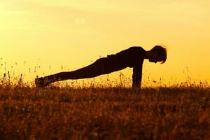 silhuett av kvinna håller på med yoga foto