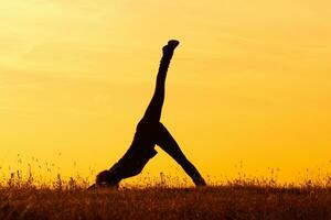 silhuett av kvinna håller på med yoga foto