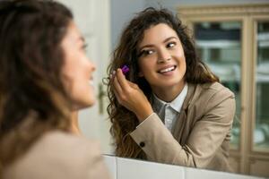 affärskvinna är applicering mascara medan framställning för arbete foto