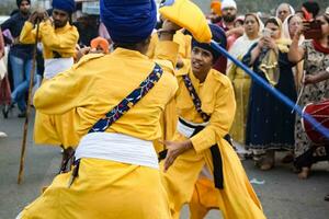 delhi, Indien, oktober 2, 2023 - sikher visa gatka och krigisk konst under årlig nagar kirtan, traditionell, procession på konto av födelsedag av guru nanak dev ji, nagar kirtan i öst delhi område foto