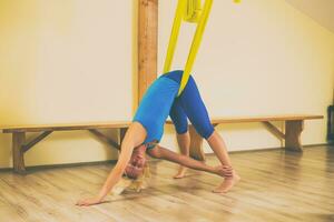 kvinna håller på med antenn yoga i de kondition studio foto