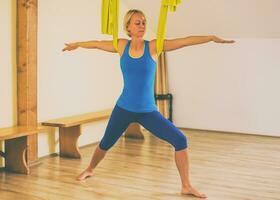 kvinna håller på med antenn yoga i de kondition studio foto