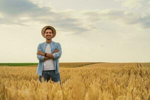 Lycklig jordbrukare är stående i hans växande vete fält foto