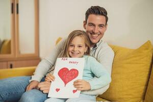 Lycklig far och dotter innehav hälsning kort med hjärta former och text. fars dag begrepp. foto