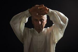 senior man åtnjuter övning tai chi inomhus- foto