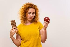 ingefära kvinna är ledsen eftersom hon har till äta frukt, hon skulle snarare äta choklad foto