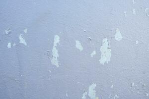 gammal cement vägg skala exteriör bakgrund med blå måla peeling låg kvalitet, knäckt vägg foto