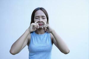 asiatisk kvinna omslag henne näsa med henne finger foto