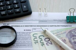information handla om några inkomst från monetär huvudstad, grop-8c form på revisor tabell med penna och putsa zloty pengar räkningar foto