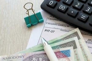 deklaration av de belopp av tjänade inkomst eller uppkommit förlust grop-37 beskatta former på revisor tabell med penna och putsa zloty pengar räkningar foto