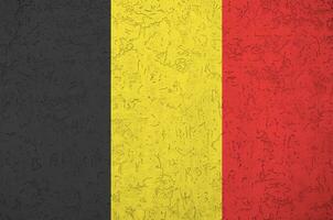 belgien flagga avbildad i ljus måla färger på gammal lättnad putsning vägg. texturerad baner på grov bakgrund foto