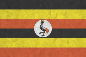 uganda flagga avbildad i ljus måla färger på gammal lättnad putsning vägg. texturerad baner på grov bakgrund foto