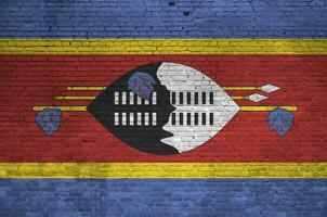 swaziland flagga avbildad i måla färger på gammal tegel vägg. texturerad baner på stor tegel vägg murverk bakgrund foto