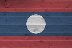 laos flagga avbildad i ljus måla färger på gammal trä- vägg. texturerad baner på grov bakgrund foto