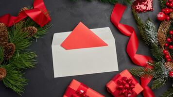 jul dekor, gåvor insvept i röd papper och en brev på en svart bakgrund foto