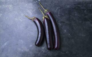 färsk brinjal på en svart betong golv foto