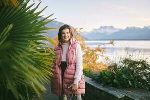 utomhus- porträtt av skön ung kvinna avkopplande förbi berg sjö, kall väder foto
