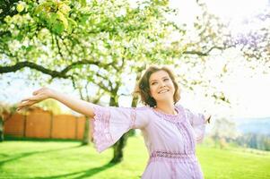 utomhus- vår porträtt av Lycklig ung kvinna njuter trevlig solig dag foto
