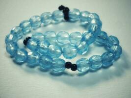 vatten- blå bön pärlor med 33 knop tillverkad av kristall klar pärlor isolerat på en vit bakgrund foto
