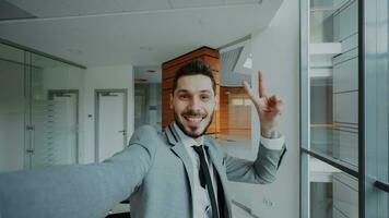 pOV av ung affärsman i kostym tar en selfie Foto och ha roligt i modern kontor inomhus
