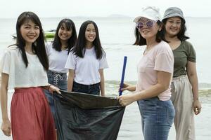 grupp av volontärer rengör hav strand foto