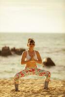 asiatisk kvinna som spelar yogaställning på havsstranden foto