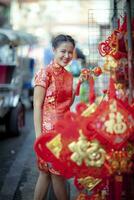 asiatisk kvinna bär kinesisk tradition kläder med kinesisk bambu fläkt leende ansikte i Yaowarat gata Kina stad av bangkok thailand foto