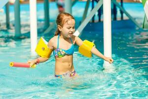 söt litet barn flicka spelar i simning slå samman foto
