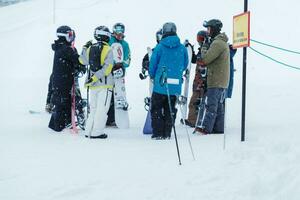 människor spelar åka skidor och snowboard i vinter- säsong. snö vinter- aktivitet begrepp foto