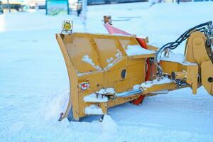 gul traktor tar bort snö från de väg och rensar de trottoar i vinter- säsong. rengöring och clearing vägar efter det snöar och snöstormar foto