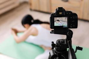 attraktiv ung kvinna som utövar yoga och skjuter video foto