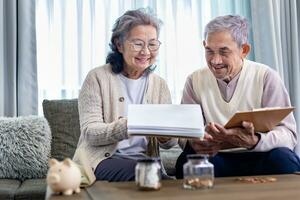 senior asiatisk par är planera på pensionering sparande fond ser på deras inkomst och bekostnad och årlig pension efter skatter för äldre lång termin finansiell investering och budget begrepp foto