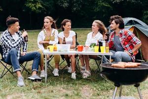 ett sällskap av vänner äter lunch på campingen foto