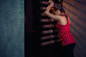 ung skön kvinna Framställ i en Gym utrusta. foto