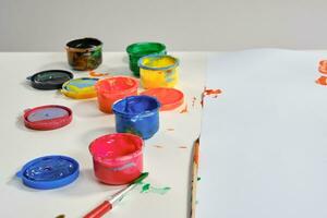 färgrik målarfärger är stående på en tabell med en vilken man. konst studio. isolerat på vit bakgrund. medium närbild. foto