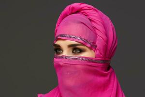 närbild skott av en ung charmig kvinna bär de rosa hijab dekorerad med paljetter. arabicum stil. foto
