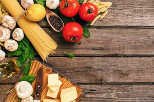 italiensk mat matlagningstomater, basilika, pasta, oliv olja och ost på trä- bakgrund, topp se, kopia Plats. foto