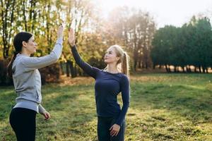 två tjejer i parken tränar och klappar händerna. foto