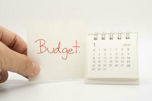budget text på papper med 2024 jan kalender på en vit bakgrund. finansiera, pengar förvaltning begrepp. foto