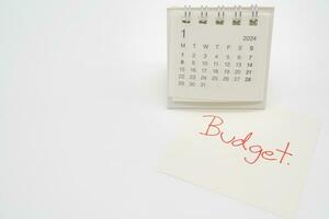 budget text på papper med 2024 jan kalender på en vit bakgrund. finansiera, pengar förvaltning begrepp. foto