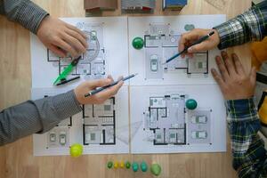 konstruktion ingenjörer diskutera och utbyta idéer med arkitekter till förbättra hus planer till träffa kund behov. en begrepp för utbyta av design idéer mellan konstruktion ingenjörer och arkitekter. foto