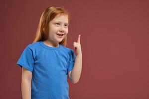 porträtt av söt rödhårig emotionell liten flicka på röd bakgrund foto