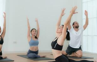 grupp av människor praktiserande yoga i en studio. yoga klass begrepp. foto