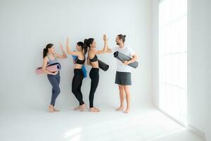 en grupp av kvinna och manlig idrottare stod och chattade i godo i de studio innan början med de yoga klass. foto